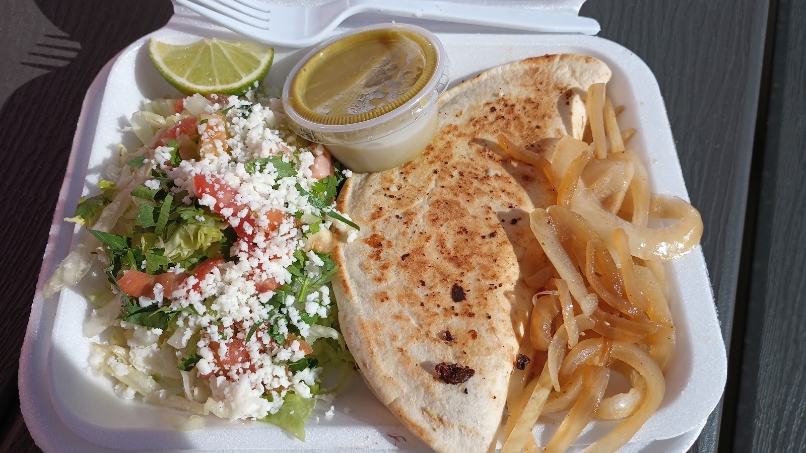 Grilled quesadilla with sautéed onions, fresh salad and salsa verde