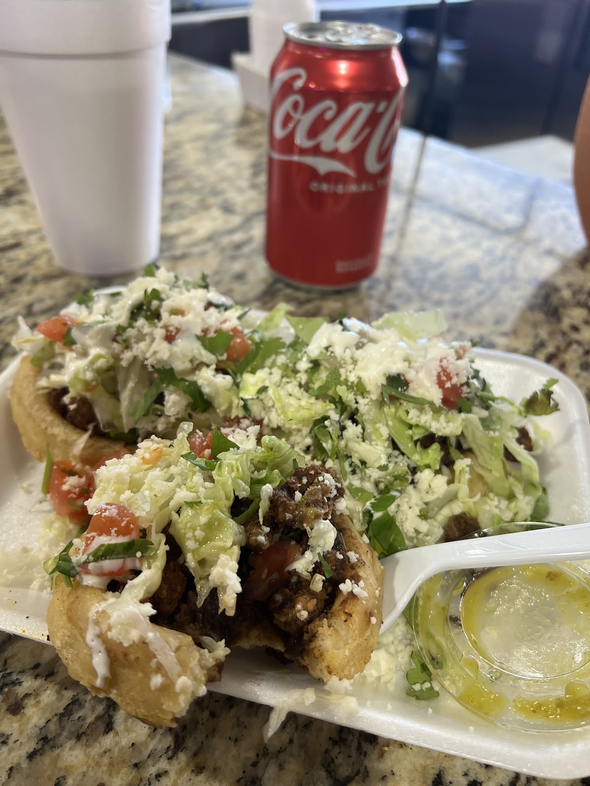 Three loaded sopes topped with shredded lettuce, pico de gallo, crema and queso fresco